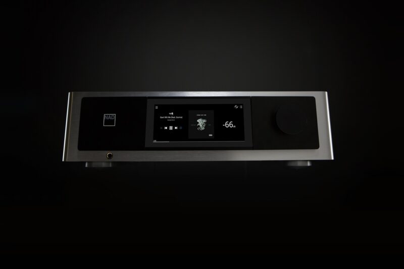 Moderner Audioverstärker mit Display und Regler vor schwarzem Hintergrund.