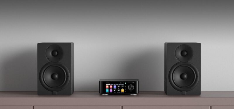 Zwei Lautsprecher und ein Audio-Receiver auf Regal