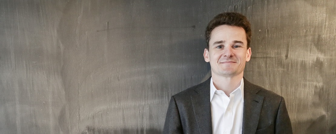 Mann im Anzug lächelt.